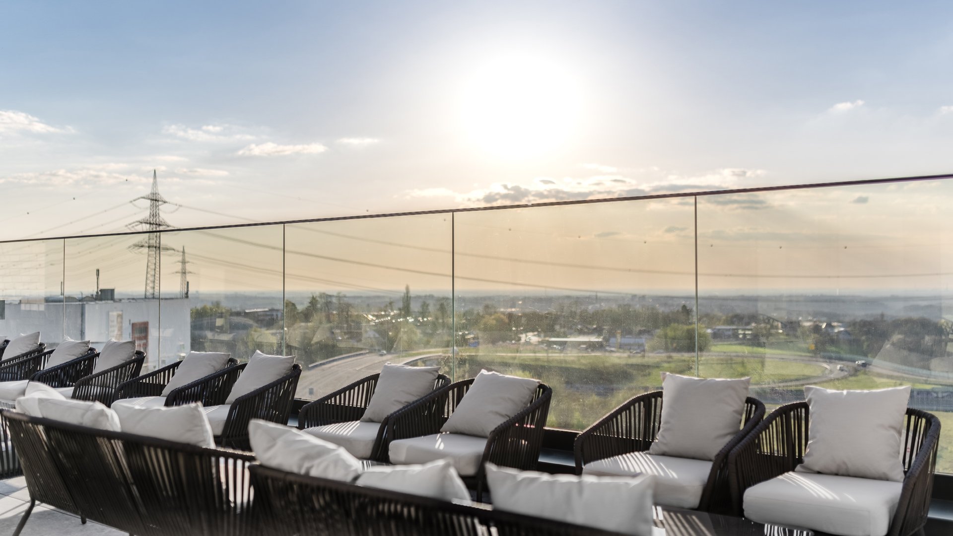 Rooftop Terrasse im Tagungshotel Aiden by Best Western in Velbert mit Loungemöbeln und weitem Blick ins Grüne bei Sonnenuntergang